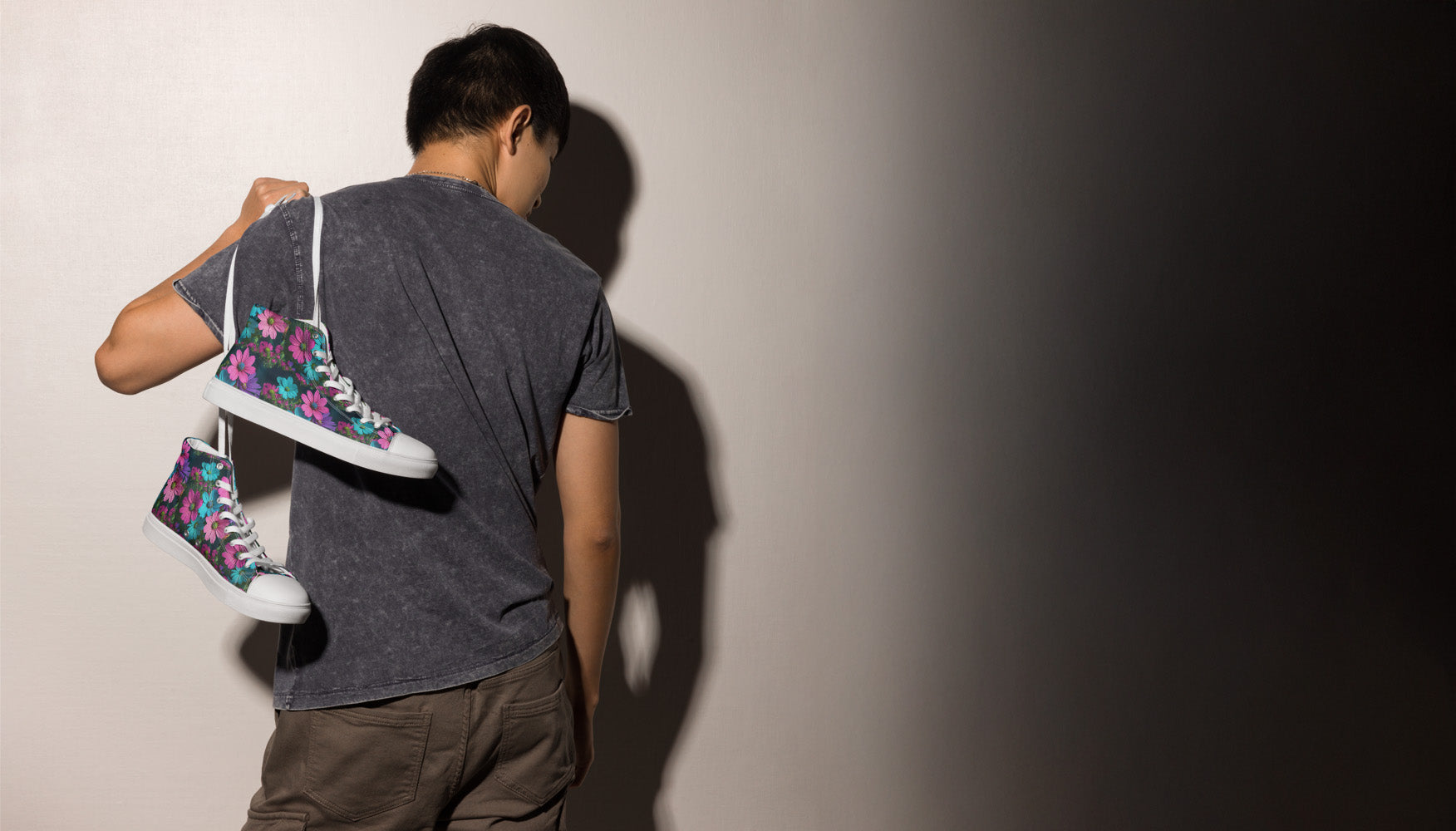 Person holding a colorful sneaker against a plain background